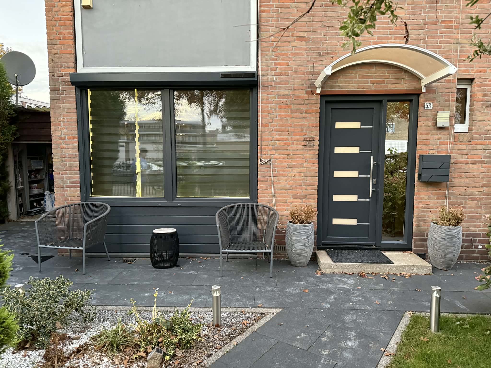 Antracietkleurig kozijn in een bakstenen voorgevel